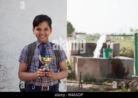 Portrait of a schoolboy holding a trophy Stock Photo