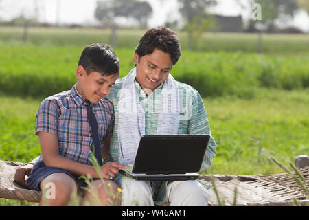Man using laptop with his son Stock Photo