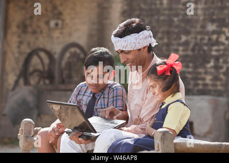 Man using laptop with his children Stock Photo