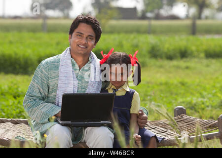 Portrait of a man using laptop with his daughter Stock Photo