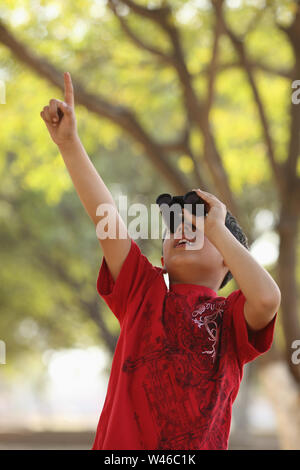 Boy looking through binoculars Stock Photo