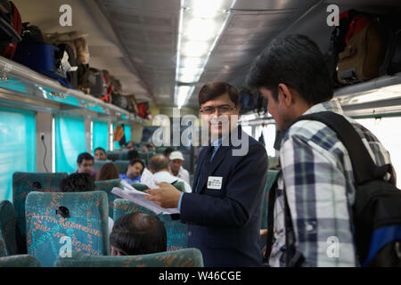 Ticket collector checking tickets in a train Stock Photo