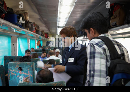 Ticket collector checking tickets in a train Stock Photo