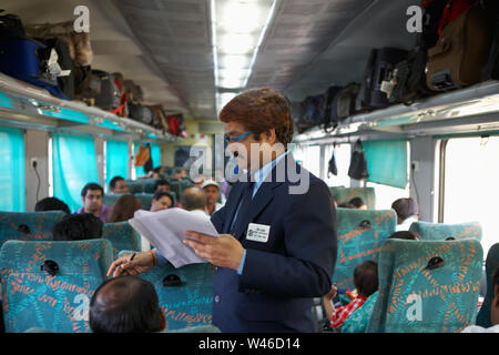 Ticket collector checking tickets in a train Stock Photo