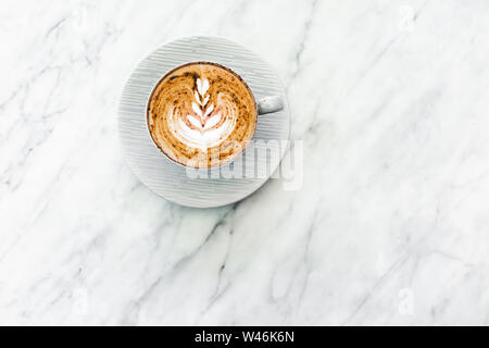 Cup of fresh coffee cappuccino with classic latte art and chocolate on white marble table trendy background. Empty place for text, copy space. Coffee Stock Photo