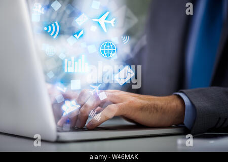 Male working on laptop with abstract multimedia icons Stock Photo