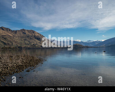 View of Lake Wanaka and southern alps in autumn with snow on the peaks, and reflections in the water Stock Photo