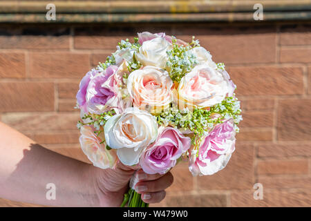 Close up view of a hand holding a  flower bouquet Stock Photo
