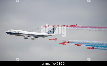 RAF Fairford, Glos, UK. 20th July 2019. Day 2 of The Royal International Air Tattoo (RIAT) with military aircraft from around the world assembling for the world’s greatest airshow which runs till 21 July. Image: A highlight of day 2 is the flypast by the RAF Red Arrows aerobatic display team in formation with a BOAC speedbird liveried Boeing 747. Credit: Malcolm Park/Alamy Live News. Stock Photo