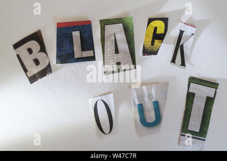 The words Black Out on a bulletin board using cut-out paper letters in the ransom note effect typography Stock Photo