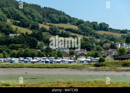 Axmouth, Devon, England, UK. July 2019.  A caravan camping site seen across the River Axe at low tide. Stock Photo