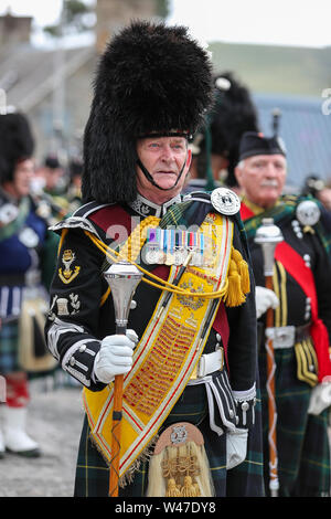 Tomintoul, Scotland. 20 July 2019  One of the most important Highland Games gathering began with the traditional parade of the local pipe bands through the town of Tomintoul and thanked by the locals at several stops along the way who provided a dram of local scotch whisky to each member of the bands. Despite heavy rain, the games continued providing entertainment to thousands of spectators including many tourists from foreign countries Stock Photo