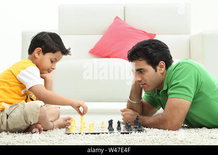 Man with his son playing chess at home Stock Photo