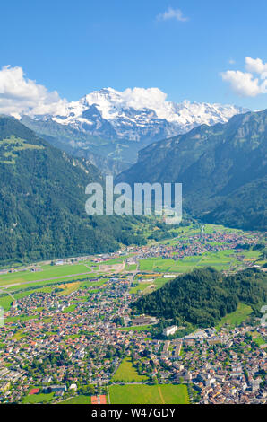 Stunning view of Interlaken and adjacent mountain ridges from the top of Harder Kulm, Switzerland. Famous mountains Eiger, Monch and Jungfrau in background. Swiss Alps. Summer Alpine landscape. Stock Photo