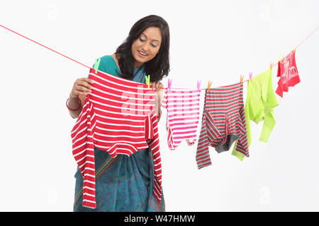 Indian young woman drying clothes and smiling Stock Photo