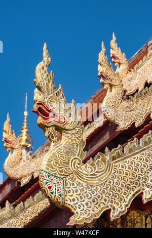 Golden dragon statues on the roof of buddhist temple in Chiang Mai, Thailand Stock Photo