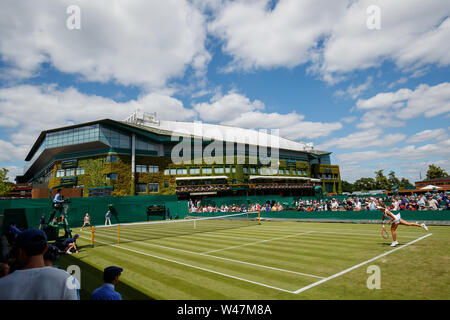 General View of Anna Karolina Schmiedlova and Monica Puig on Court 4 with Centre Court behind at The Wimbledon Championships 2019. Held at The All Eng Stock Photo