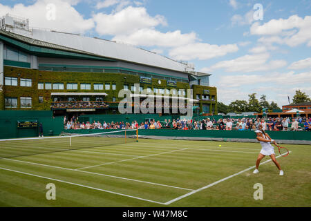 General View of Anna Karolina Schmiedlova and Monica Puig on Court 4 with Centre Court behind at The Wimbledon Championships 2019. Held at The All Eng Stock Photo