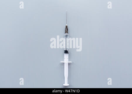 Medical syringe on gray background, give an injection and be healthy, vaccination concept. Flat lay, mockup, overhead, top view and copy space. Stock Photo