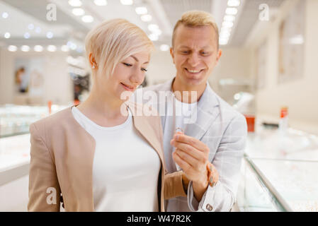 Love couple buying gold decoration. Male and female consumers