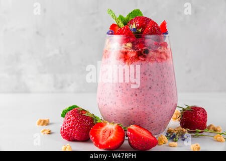 chia strawberry pudding with fresh berries, granola and mint in a glass. healthy delicious dessert. close up Stock Photo