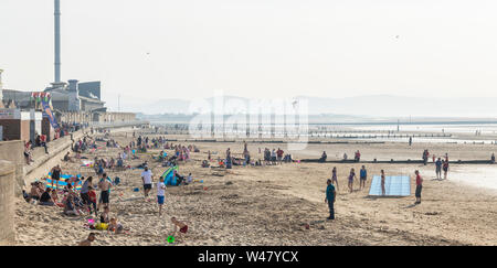 RHYL, NORTH WALES - APRIL 21, 2019: People enjoying sunny spring day at the beach, wide panoramic view. Stock Photo