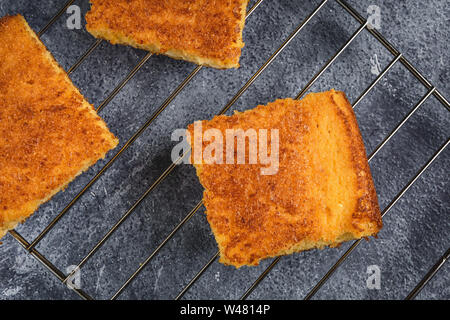 Yellow Corn Bread Squares Slices on Dark Rustic Background Stock Photo