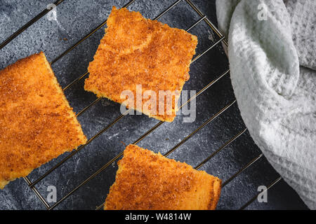 Yellow Corn Bread Squares Slices on Dark Rustic Background Stock Photo