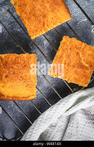 Yellow Corn Bread Squares Slices on Dark Rustic Background Stock Photo
