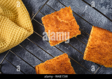 Yellow Corn Bread Squares Slices on Dark Rustic Background Stock Photo