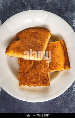 Yellow Corn Bread Squares Slices on Dark Rustic Background Stock Photo