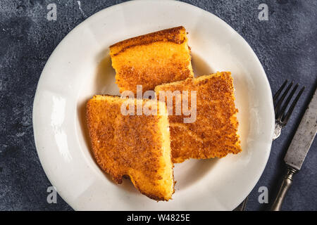 Corn Bread Squares Slices in White Plate on Dark Blue Rustic Background Stock Photo