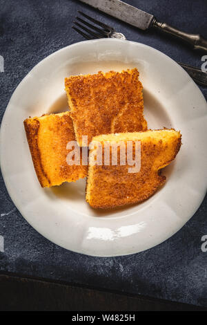 Corn Bread Squares Slices in White Plate on Dark Blue Rustic Background Stock Photo