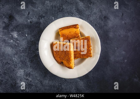 Corn Bread Squares Slices in White Plate on Dark Blue Rustic Background Stock Photo