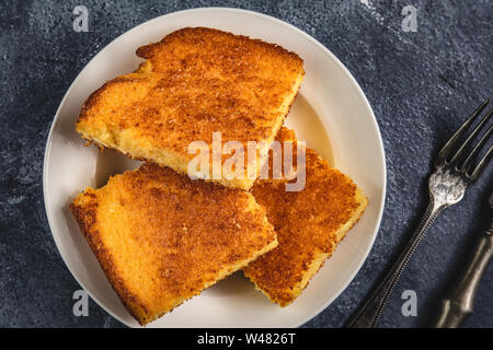 Corn Bread Squares Slices in White Plate on Dark Blue Rustic Background Stock Photo