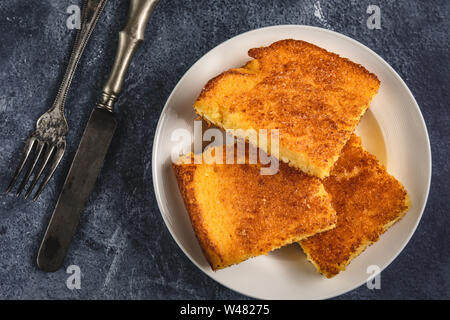 Corn Bread Squares Slices in White Plate on Dark Blue Rustic Background Stock Photo