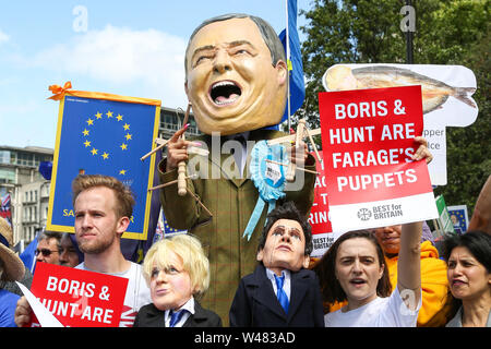 A stilts-walker wearing a giant Nigel Farage's head pulling two puppets, the Conservative leadership candidates Boris Johnson and Jeremy Hunt, during the “No to Boris. Yes to Europe” march in central London. Stock Photo