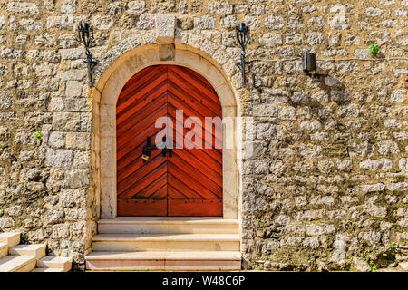 Old wooden entrance gate amd stone steps of the ancient Citadel fortress in Budva Old Town, in Montenegro, Balkans Stock Photo