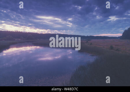 Magical sunset in the countryside. Rural landscape in the evening. Aerial view of the lake Stock Photo