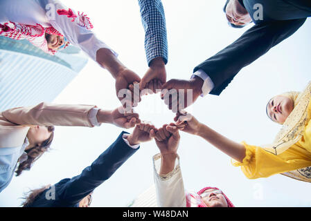 Multiethnic group of young collaboration team standing hands together . Teamwork Concepts. Stock Photo