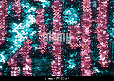 Coral and turquoise iridescent sequins on fabric. Festive trendy background. Stock Photo