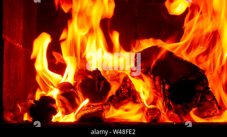 Wallpaper with a bright fire inside the brazier. Flame of fire. Preparation for cooking barbecue, kebabs. Hot coal with lights. Stock Photo