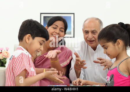 Indian boy and girl playing ludo with their grandparents