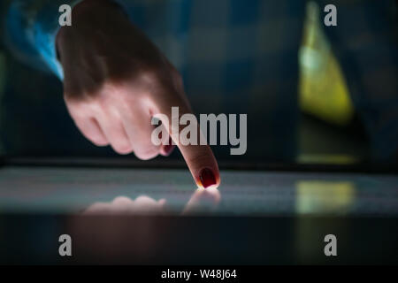 Woman using interactive touchscreen display at modern museum or exhibition Stock Photo