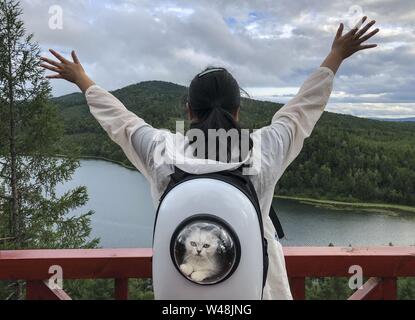 (190721) -- BEIJING, July 21, 2019 (Xinhua) -- A tourist visits the Tianchi Lake in Arxan, one 'natural oxygen bar,' north China's Inner Mongolia Autonomous Region, Aug. 5, 2018. As more and more Chinese people are choosing to visit places that have fresh air, thick forests and are rich in negative ions, ecotourism becomes a fresh favoured choice across the country. According to a report by the China Meteorological Service Association, trips to the regions granted as 'natural oxygen bars' by the association surged over 200 percent year on year in 2018. (Xinhua/Yin Gang) Stock Photo