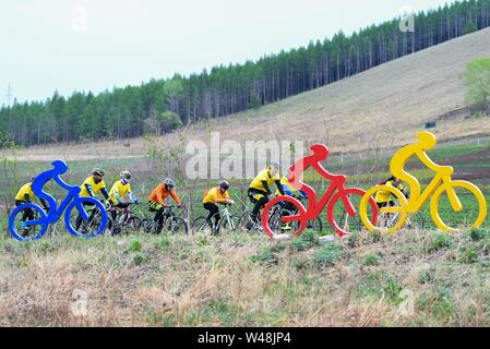 (190721) -- BEIJING, July 21, 2019 (Xinhua) -- Cycling lovers ride bikes in Arxan, one 'natural oxygen bar,' north China's Inner Mongolia Autonomous Region, May 20, 2018. As more and more Chinese people are choosing to visit places that have fresh air, thick forests and are rich in negative ions, ecotourism becomes a fresh favoured choice across the country. According to a report by the China Meteorological Service Association, trips to the regions granted as 'natural oxygen bars' by the association surged over 200 percent year on year in 2018. (Xinhua/Peng Yuan) Stock Photo