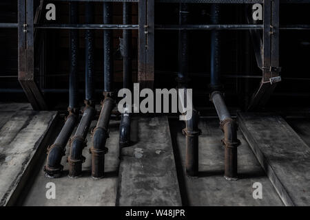 Dirty black pipes coming out of concrete wall. Texture background graphic asset. Stock Photo