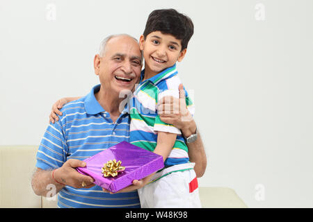 Boy receiving gift from her grandfather Stock Photo