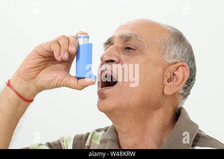Old man using asthma inhaler Stock Photo