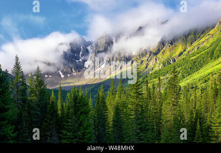 Mountain peaks are shrouded in thick fog. Summer morning in Siberian mountains. East Sayan. Tyva Republic. Central Asia Stock Photo